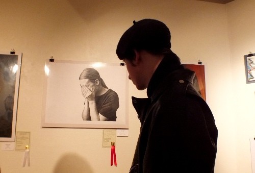 A visitor the awards ceremony Wednesday for This Century Art Gallery’s high school show, with the second place piece, “Self Portrait,” by Sophie Maize (Hannah S. Ostroff/WYDaily)