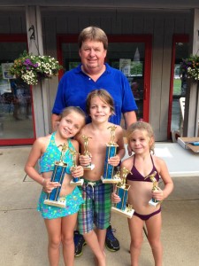 Harold Baker poses with a trio of young swimmers. (Submitted)