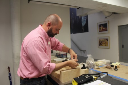 Senior Curator Michael Lavin taught himself how to braze metal so he could hand-make the mounts for the artifacts in this exhibit. (Elizabeth Hornsby/WYDaily)