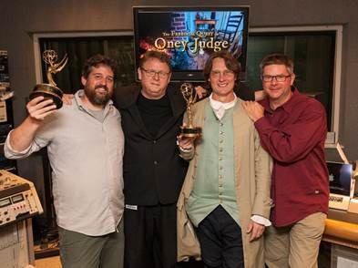 Colonial Williamsburg employees Wayne Hill and Charles White hoist Emmy awards. (Photo courtesy of Colonial Williamsburg)