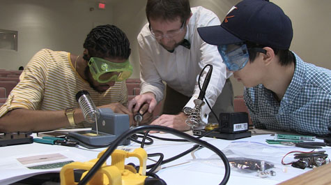 Jake Joseph helps students in W&M Professor Christopher DeLaurenti's computer music class solder metals together to create hand-built analog synethesizers. (W&M News)