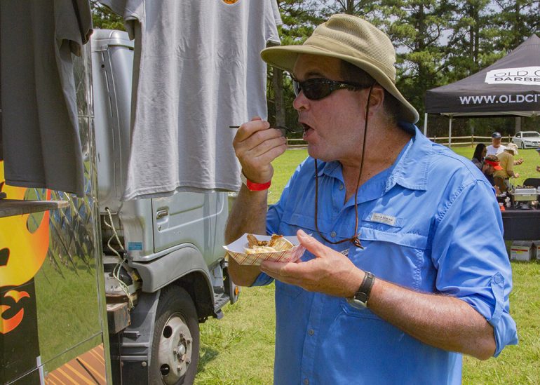Tom Belden tries the offerings from Suck On This BBQ at the inaugural Williamsburg Pro-Am BBQ Cook Off on Sunday, July 1, 2018, at Jamestown Beach Event Park. (WYDaily/Bryan DeVasher)