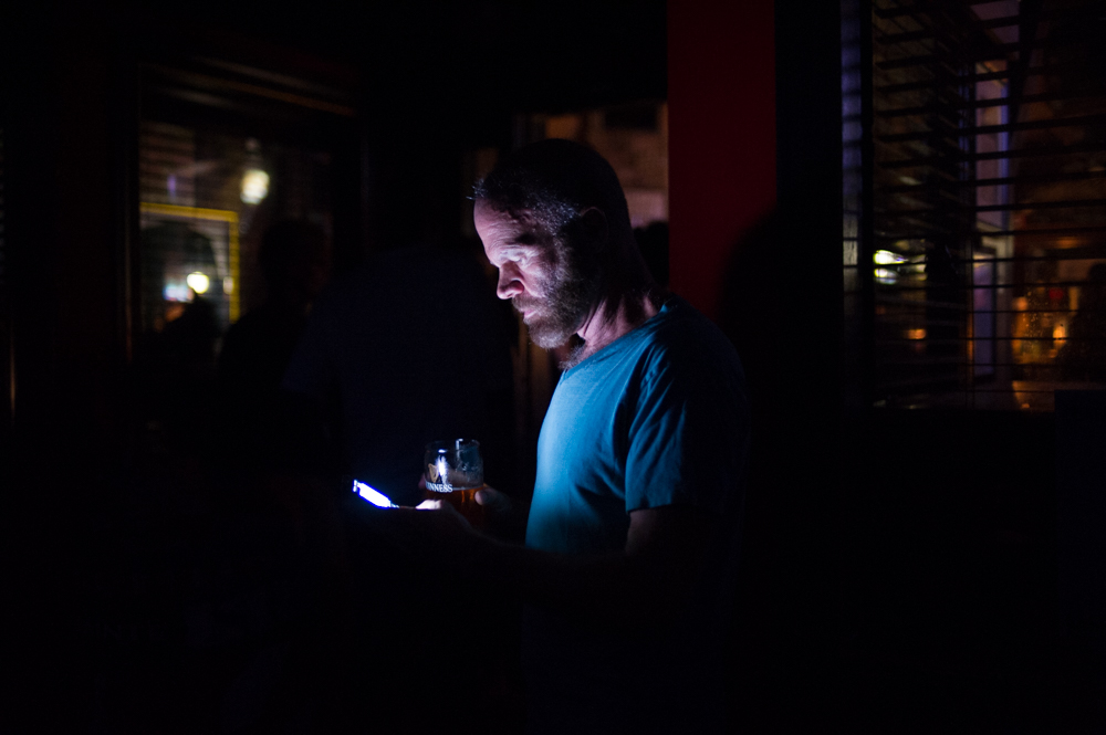 Tom Noonan looks at his phone outside Slainte Irish pub Sunday night, Sept. 16, 2018,, in Wilmington, North Carolina. (Port City Daily photo | Mark Darrough)