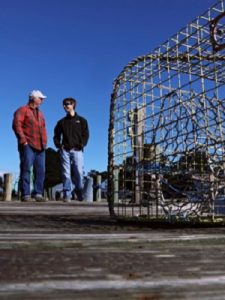VIMS graduate student Jim DelBene (R) and professional mentor J.C. Hudgins discuss derelict crab pots along a dock on Gwynn's Island. (Southside Daily/Aileen Devlin/Virginia Sea Grant)