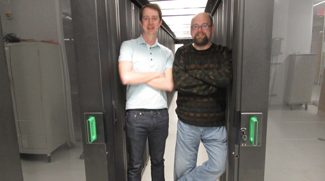 William & Mary economist Nathaniel Throckmorton (left) walks through a portion of the High Performance Computing cluster with Eric Walter, director of the facility. Throckmorton used the HPC facilities to number-crunch an economic simulation. (WYDaily/Courtesy of Joseph McClain)