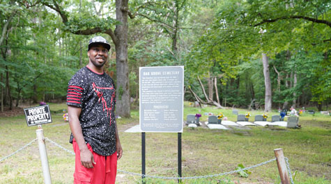 Travis Harris Ph.D. '19 stands at the site of the historic Oak Grove Cemetery that was part of the African American neighborhood where the U.S. Navy built Camp Peary in 1942-43. Oak Grove Baptist Church owns the cemetery. (WYDaily/Courtesy of Stephen Salpukas)