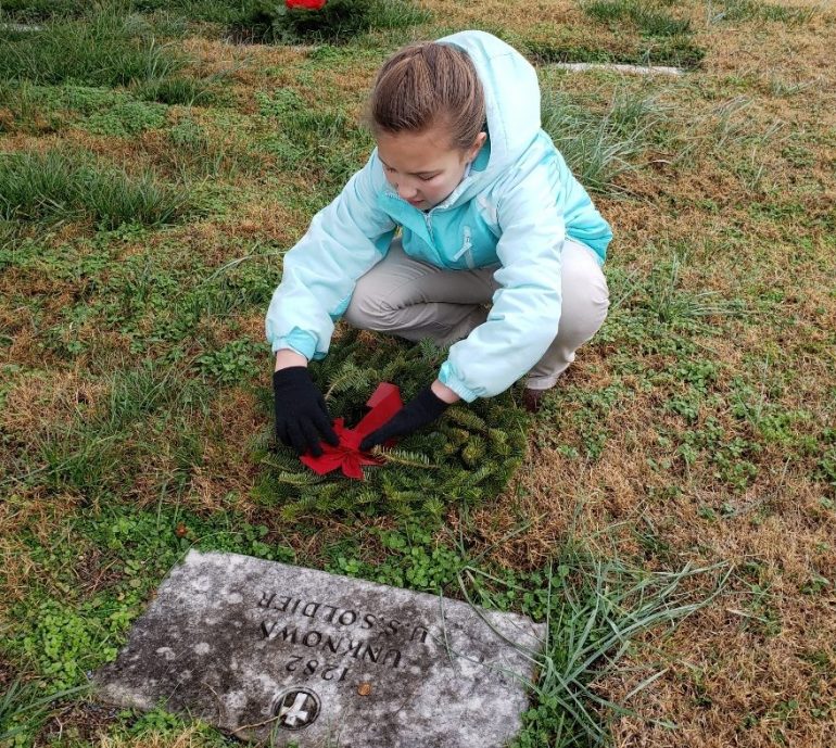Candace Smeltzer putting a wreath on a headstone at the Yorktown National Cemetery in 2019. (WYDaily/Courtesy of Vanessa Smeltzer)